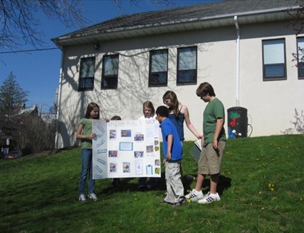 Students with their poster about their painted rain barrel project.