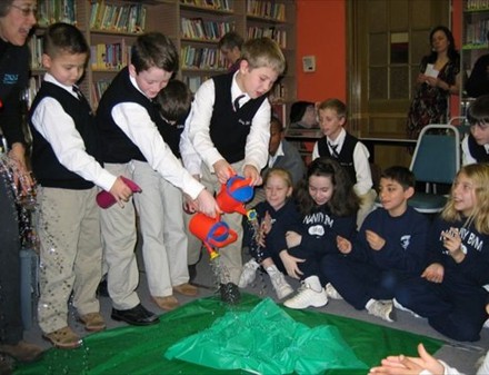 Students pouring water on a watershed model.