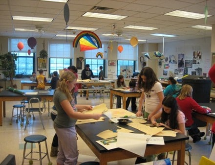 Students working on designs for their rain barrel in an art classroom.