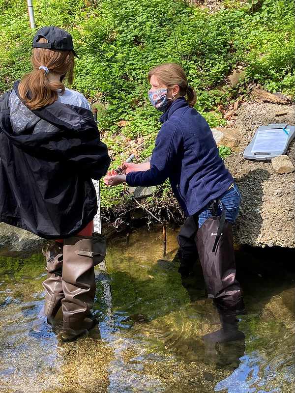 Patty Haug shows Elisabeth Ruschmann how to monitor water quality in streams