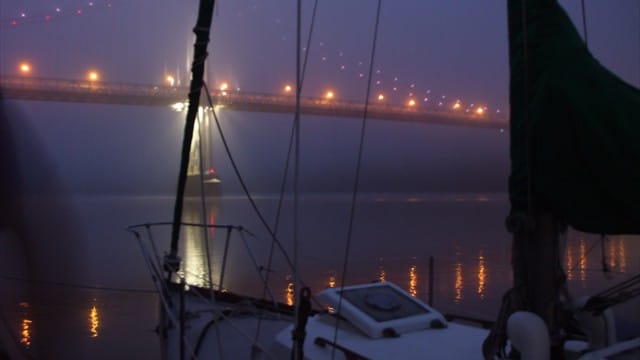 Lights on a bridge on a foggy night on the Hudson River.