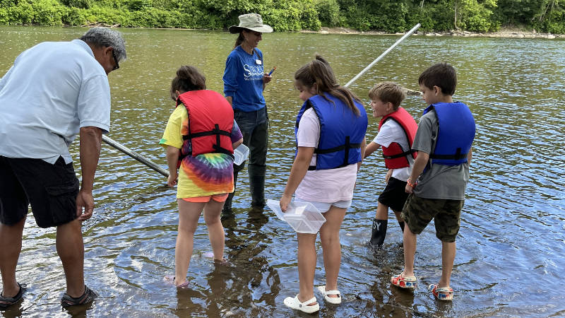 Seneca Nation children explore the river's edge with Tara Muenz.