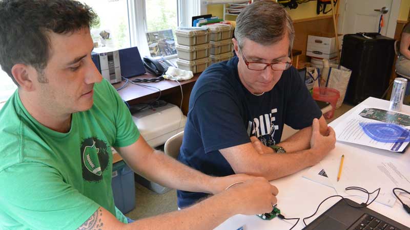 Photo of two men building an environmental monitoring sensor