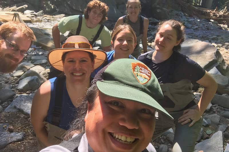 A group of six Stroud Center staff members and interns smile as a National Park Service staff member takes a selfie.