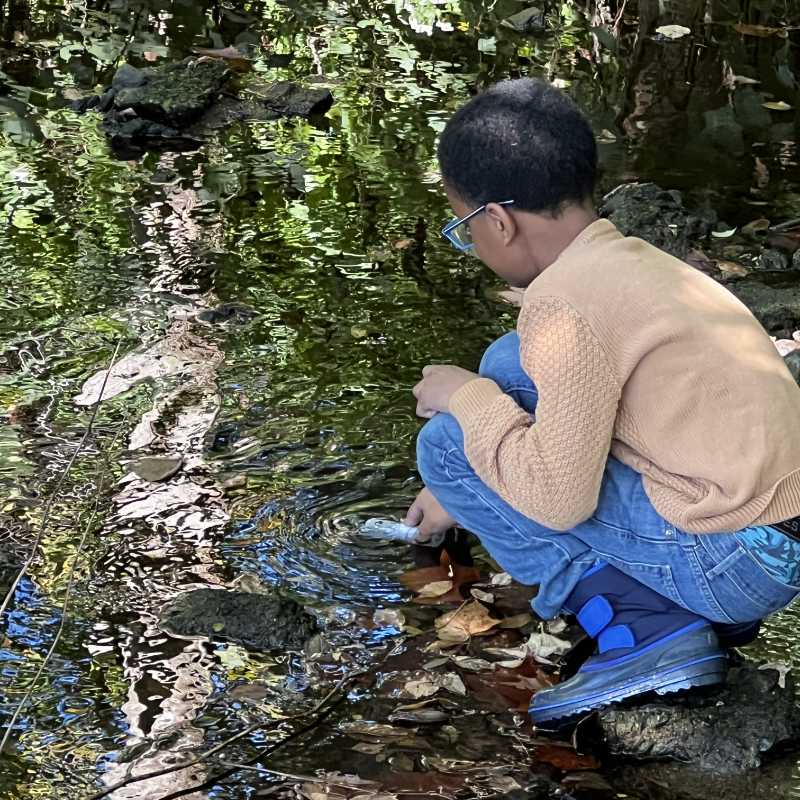 A young man takes a stream salt sample.