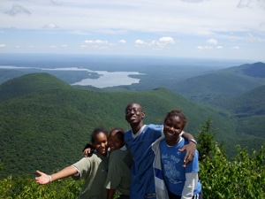 Four students hug on a mountaintop in New York.