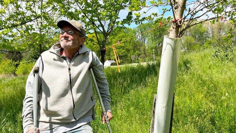 Tom Best smiles as he stands in a young riparian buffer.