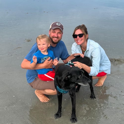 Toren Peterson on a beach with his wife, son, and dog.