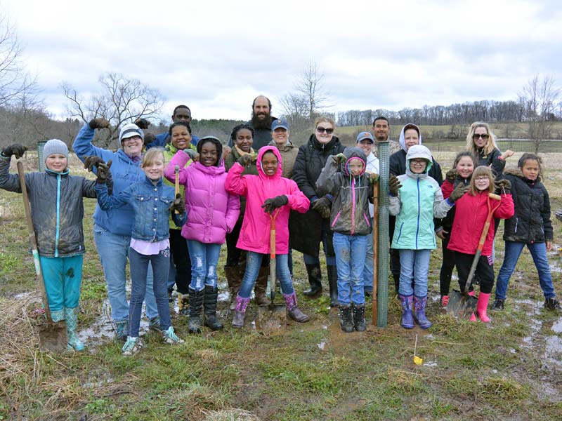 Photo of Brownie Girl Scouts and leaders planting trees.