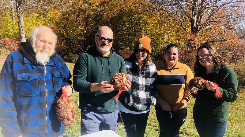 Five workshop participants holding their artificial leaf packs.